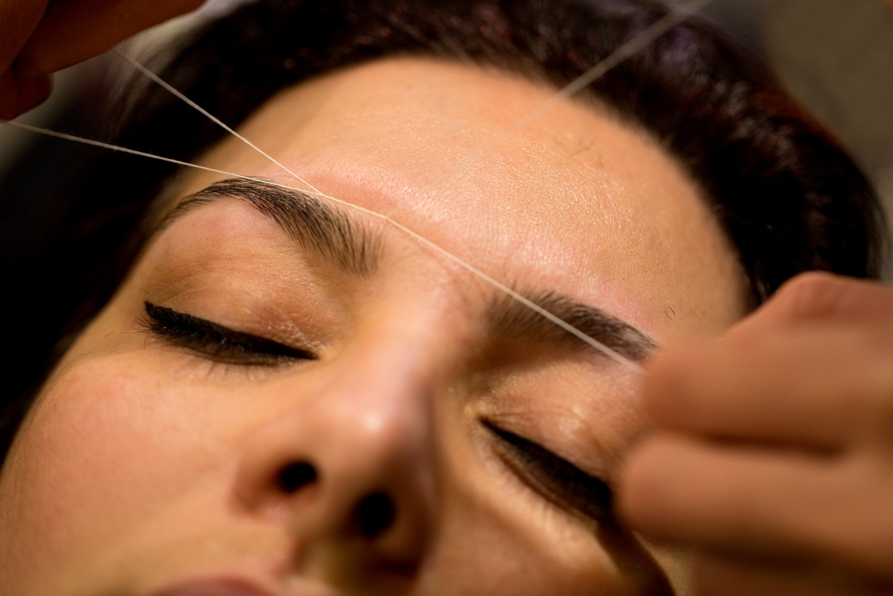 Eyebrow threading in progress macro close up